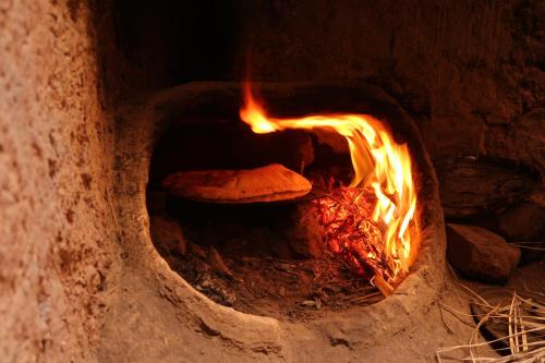 a pizza is cooking in a brick oven at Gite Elkhorbat in Tinejdad