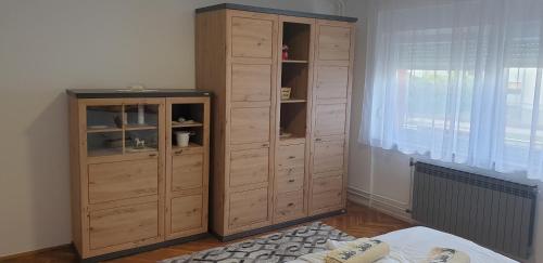 a large wooden cabinet in a room with a window at Apartment My Home in Varaždin