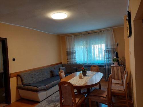 a living room with a couch and a table with chairs at Apartment My Home in Varaždin