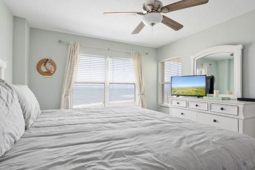 1 dormitorio con 1 cama y TV de pantalla plana en Sea Winds 501 - Corner Breeze en Ormond Beach