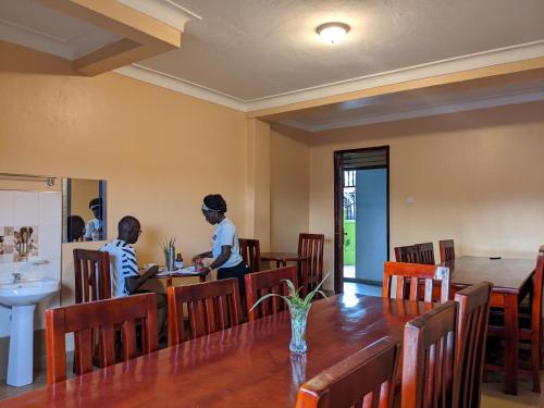 two people sitting at a table in a restaurant at Kasenene Legacy Hotel in Fort Portal