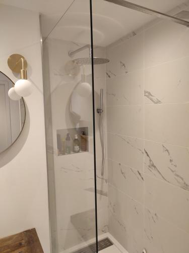 une salle de bain avec une douche avec une porte vitrée dans l'établissement Romy, à Boulogne-sur-Mer