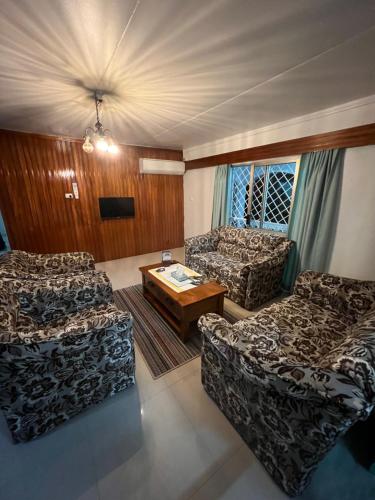 a living room with two couches and a coffee table at Hill Bottom Accommodation in Suva
