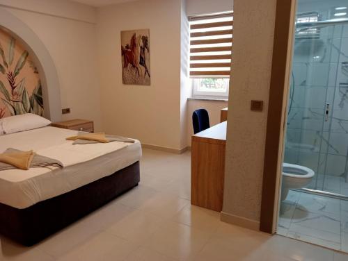 a bedroom with a bed and a bathroom with a shower at Side Leon Otel in Side