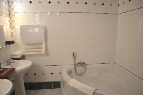 a bathroom with a tub and a sink and a bath tub at Château De La Caze Piscine & Spa - Ste Enimie in Sainte-Énimie
