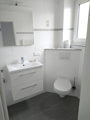 漢諾威的住宿－Bungalow in Messenähe，白色的浴室设有卫生间和水槽。