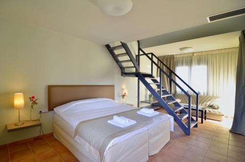 1 dormitorio con 1 cama y escalera de caracol en Ellopia Point Hotel, en Ioannina