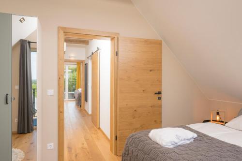 a bedroom with a bed and a staircase in a house at WeinZeit Chalets in Gamlitz
