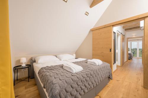 a bedroom with a large bed with two pillows at WeinZeit Chalets in Gamlitz