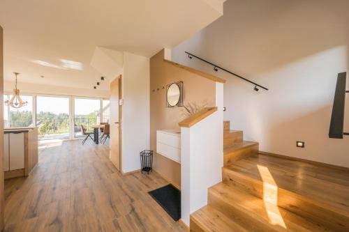 a living room with wood floors and a staircase at WeinZeit Chalets in Gamlitz