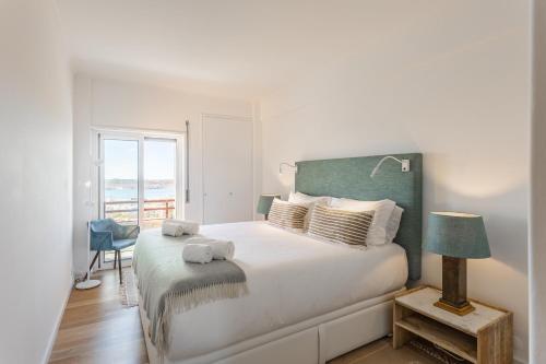 a white bedroom with a large bed and a window at Belvedere TM Flat With a Magnificent View in Lisbon