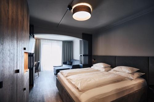 a bedroom with a large bed and a desk at Hotel Gerl in Salzburg