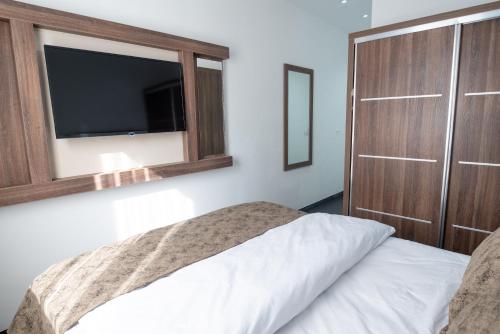 a bedroom with a bed with a tv on the wall at Hotel Cataleya in Almere