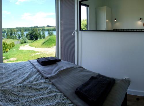 a bedroom with a bed and a large window at Rospuda B in Supienie