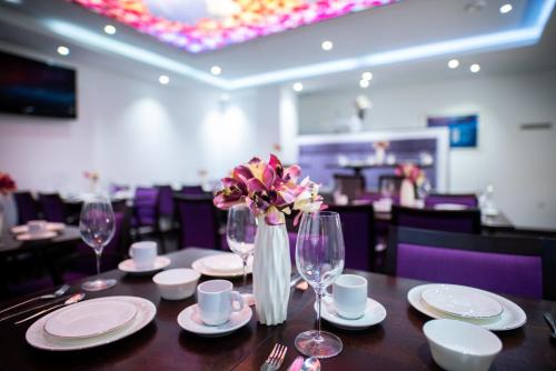 a table in a restaurant with a vase of flowers at Hotel Cataleya in Almere