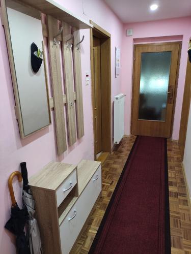 een hal met roze muren en een houten deur bij Apartment Rose in Jesenice