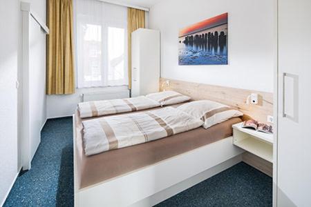 ein Schlafzimmer mit einem großen Bett in einem Zimmer in der Unterkunft Villa Rosenhof in Norderney