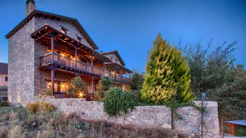 a large wooden house with a balcony on a hill at Pera Alonia Guest House in Kato Trikala Korinthias