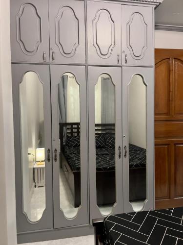 d'une armoire blanche avec des miroirs dans la chambre dans l'établissement NEW Modern Vacation Home Apartelle, à Iriga City