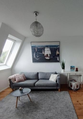 ein Wohnzimmer mit einem Sofa und einem Tisch in der Unterkunft Meer-Harmonie in Kiel