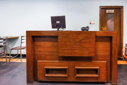 a wooden cabinet with a television on top of it at Hotel O Sai Residency Near SR Nagar metro station in Hyderabad