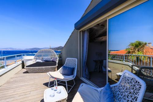 a balcony with chairs and a view of the ocean at Best Western Premier Santa Maria in LʼÎle-Rousse