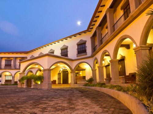 an exterior view of a building with a cobblestone courtyard at Hotel Los Portales in Chinandega