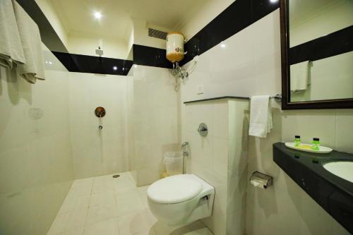 a bathroom with a white toilet and a sink at Hotel Maru Casa in Jaipur