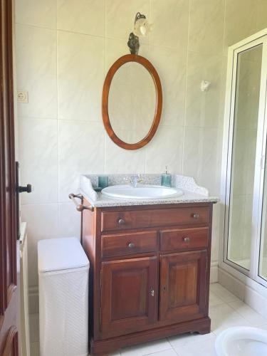 a bathroom with a sink and a mirror at CASA CAMPO DA FEIRA in Felgueiras