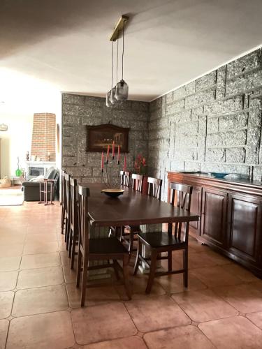 CASA CAMPO DA FEIRA في فيلجويراس: غرفة طعام مع طاولة وكراسي خشبية