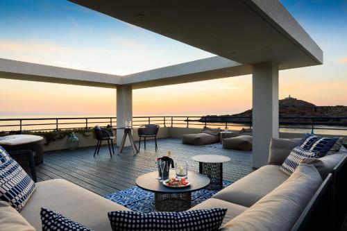 a living room with a couch and tables on a deck at Best Western Premier Santa Maria in LʼÎle-Rousse