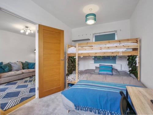 ein Schlafzimmer mit einem Etagenbett und einem Sofa in der Unterkunft Quiet Seaside Getaway with Hot Tub, Herne Bay in Greenhill