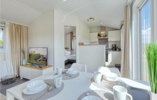 uma sala de jantar branca com uma mesa e cadeiras brancas em Beautiful Home In Ssel With Wifi And 2 Bedrooms em Süsel
