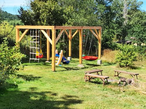 a playground with two benches and a swing at Taneček - malý apartmán u rodinného domu in Stvolínky