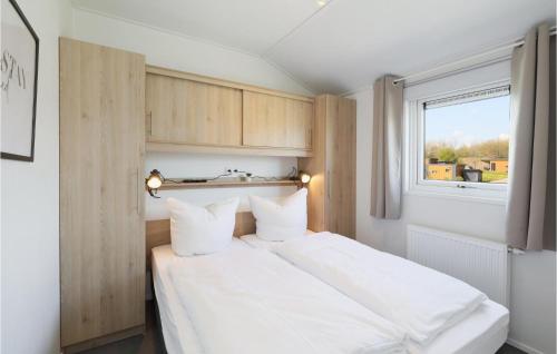 1 dormitorio con 1 cama con sábanas blancas y ventana en Lovely Home In Ssel With House A Panoramic View, en Süsel