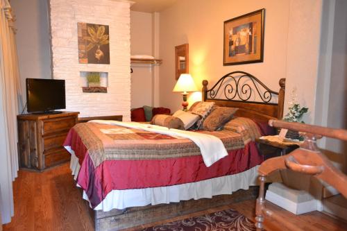 a bedroom with a large bed and a television at Sheldon Street Lodge in Prescott