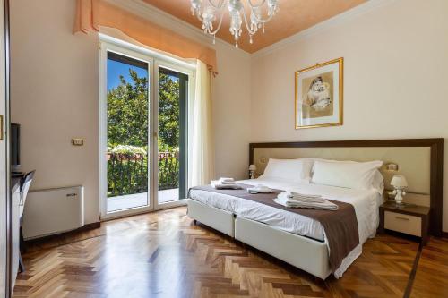 een slaapkamer met een bed en een groot raam bij Villa Carra by Perle di Puglia in Parabita