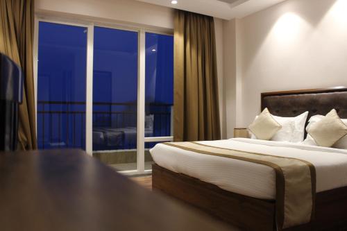 a hotel room with a bed and a large window at Peaks And Pines Resort in Lansdowne