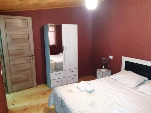 - une chambre avec un lit blanc et un miroir dans l'établissement Aleqs, à Tbilissi