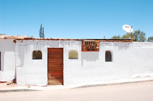 un antiguo edificio blanco con puerta de madera en La Casa Blanca en San Pedro de Atacama