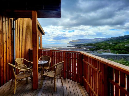 a porch with chairs and a table on a balcony at Hótel Flókalundur in Brjánslækur