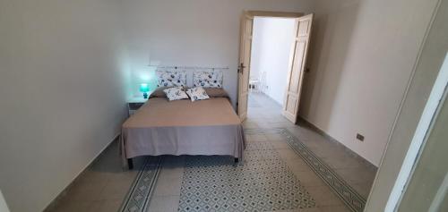 a bedroom with a bed and a hallway at A 2 passi dal mare - grazioso trilocale a Locri in Locri