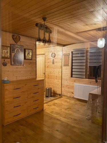 a room with wooden walls and a dresser in a room at Casa Eden Fit in Făget