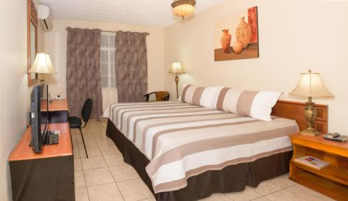 En eller flere senge i et værelse på Hotel Tropico Inn