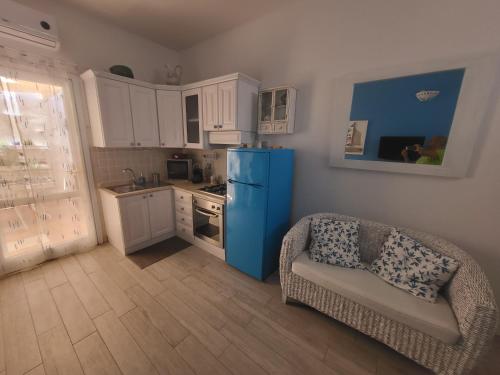Casa Celeste في كالاسيتا: مطبخ صغير مع ثلاجة زرقاء وأريكة