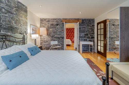 ケベック・シティーにあるCondo de Lux Le Méribel du Vieux-Québecの石壁のベッドルーム1室(大型ベッド1台付)