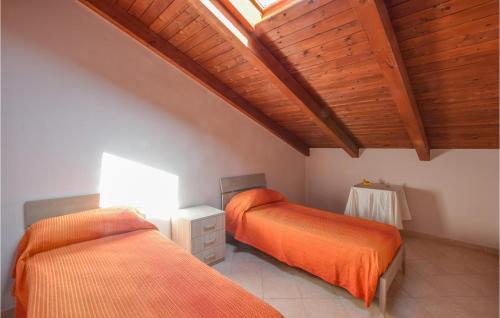 2 Betten in einem Zimmer mit Holzdecken in der Unterkunft Awesome Apartment In Limbadi With 2 Bedrooms And Wifi in Limbadi