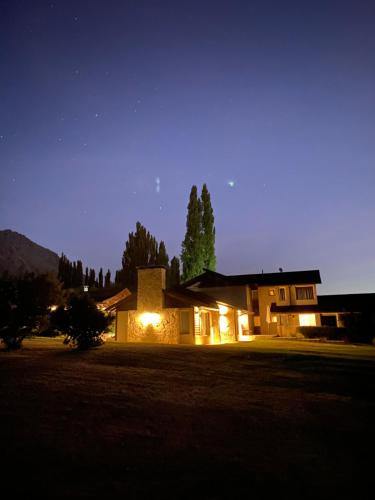una casa illuminata di notte con luci accese di La Aguada a El Bolsón