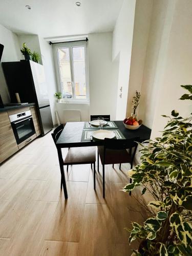 a living room with a table and chairs in a room at Appartement « cocooning » au bord du Loing in Nemours