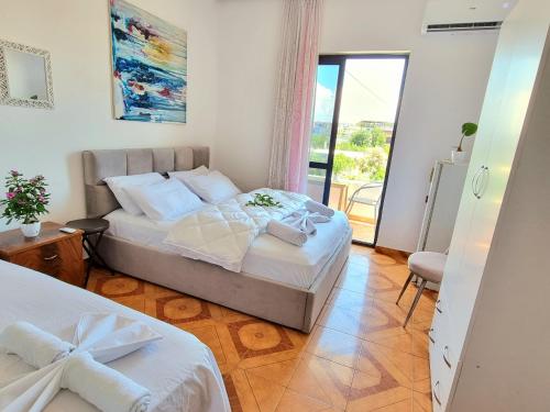 ドゥラスにあるGUEST HOUSE VILA ELEZIのベッドルーム1室(ベッド2台付)、バルコニーが備わります。